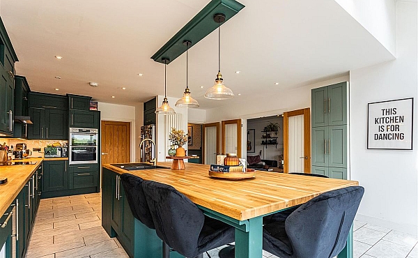 Room: Kitchen | A well-maintained kitchen featuring a dining table, chairs, cabinetry, and essential appliances.