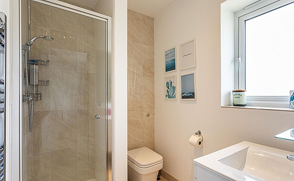 Room: Bathroom 1 | A clean and well-maintained bathroom featuring a toilet, sink, mirror, and tiled walls.