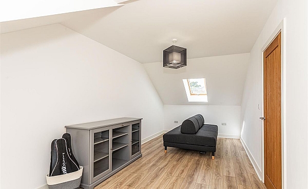 Room: Bedroom 4 | A well-maintained living room featuring laminate flooring, wooden cabinetry, and seating.