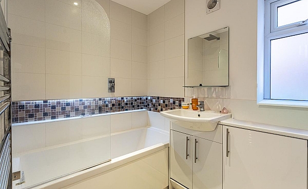 Room: Bathroom 4 | A clean, well-maintained kitchen and bathroom area featuring a sink, cabinetry, and a bathtub with tiled surfaces.