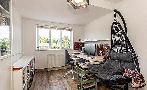 Room: Bedroom 6 | A well-lit interior room featuring furniture including chairs, a chest of drawers, and a shelf, with a window providing natural light.
