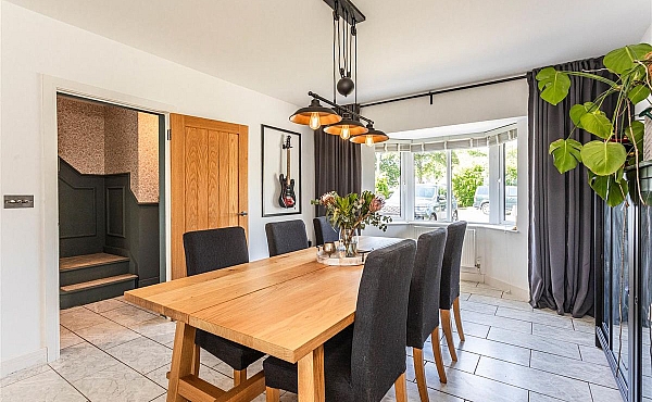Room: Dining Room | A well-maintained dining room featuring a wooden table, four chairs, cabinetry, a window, and hardwood flooring.