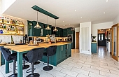Room: Kitchen | A well-maintained kitchen and dining area featuring cabinetry, a countertop, a sink, and multiple chairs.