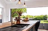 Room: Kitchen | A well-maintained kitchen featuring cabinetry, a countertop with a sink, and a window providing natural light.