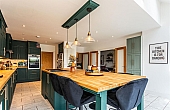 Room: Kitchen | A well-maintained kitchen featuring a dining table, chairs, cabinetry, and essential appliances.