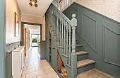 Room: Ground Floor Hallway | An indoor staircase with a handrail and balusters, featuring detailed molding and flooring, within a well-maintained property.