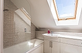 Room: Bathroom 3 | A clean and well-maintained bathroom featuring a sink, window, and tiled interior.