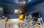 Room: Bedroom 3 | A well-furnished indoor room featuring a television, multiple chairs, a desk, and a ceiling fan.