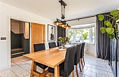 Room: Dining Room | A well-maintained dining room featuring a wooden table, four chairs, cabinetry, a window, and hardwood flooring.