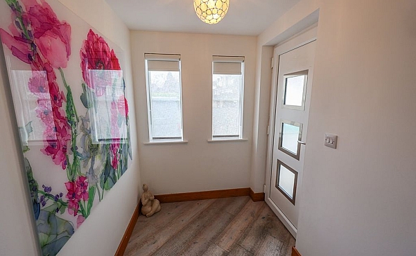 Room: Front Porch | An indoor room featuring a window, door, painted walls, a ceiling, and a wooden floor. | Accessibility: Photograph showing an indoor room with painted walls, a wooden floor, a ceiling with lighting, a window allowing natural light, and a door providing access to the space.