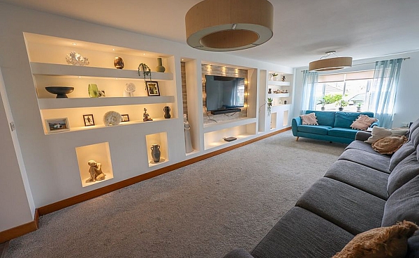 Room: Living Area | A cozy indoor room featuring a sofa bed, a loveseat, pillows, shelving, and a clean floor and ceiling. | Accessibility: Photograph showing a cozy indoor room with a light-colored sofa bed and matching loveseat, adorned with pillows, against a wall with shelving, illuminated by soft, natural lighting, with a clean, smooth floor and ceiling.